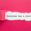 "Everyone Has A Story " written under torn pink paper