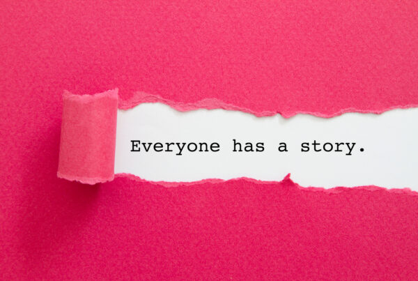 "Everyone Has A Story " written under torn pink paper