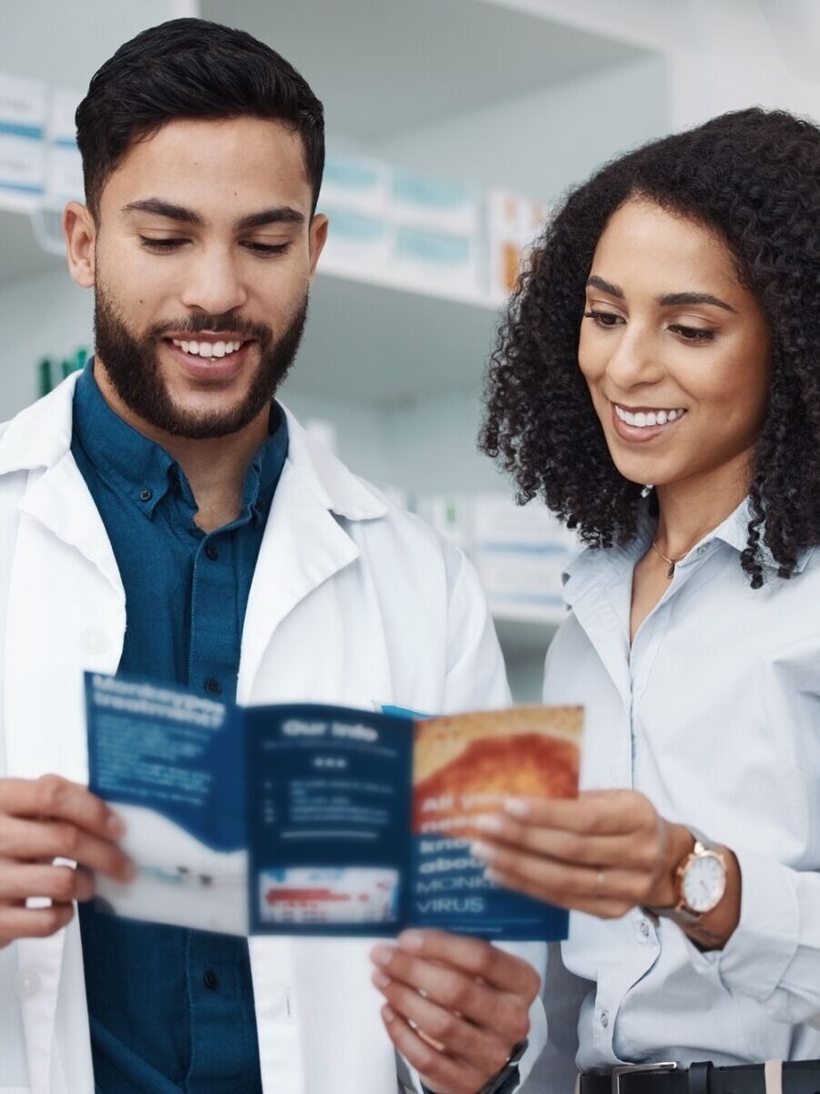 Medical staff in a pharmacy reading a healthcare brochure